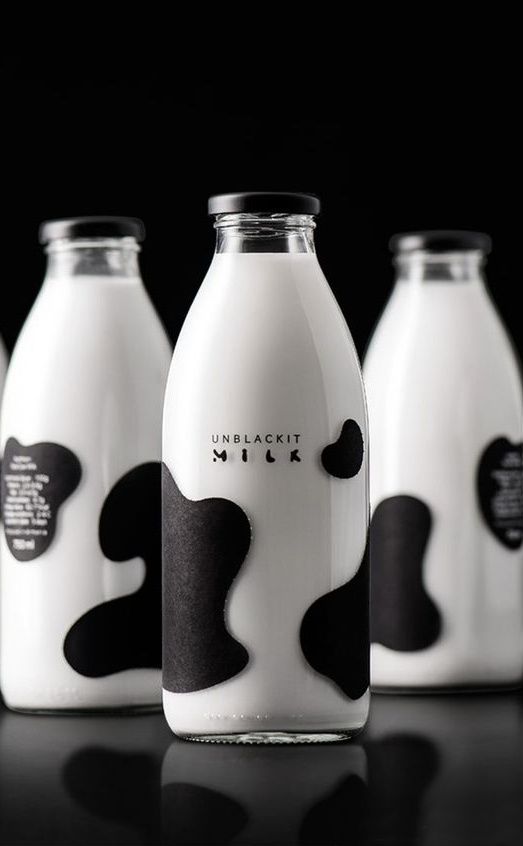 six milk bottles with black and white designs on them