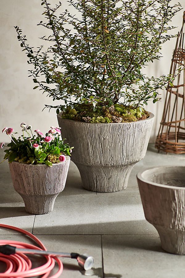 two planters with plants in them sitting on a table next to wires and wire