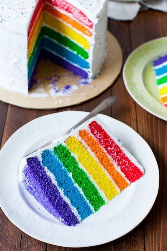 a slice of rainbow cake on a plate