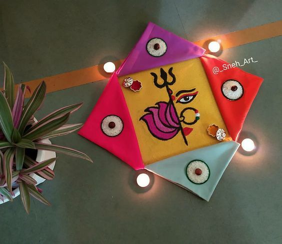 three colorful kites sitting on top of a table next to a potted plant