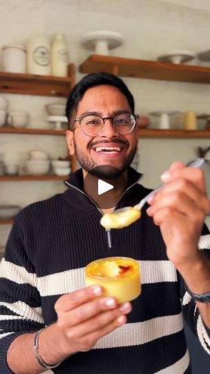 a man holding a spoon in his right hand and eating something out of a bowl