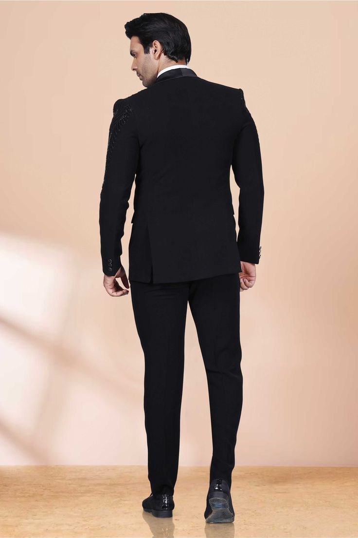 This luxurious tuxedo features stunning cutdana and black pearls, adding a touch of elegance and sophistication to any formal event. The intricate design and premium materials truly make it a one-of-a-kind piece, elevating your style and making a statement of refinement. Designer Black Tuxedo For Groom, Black Tuxedo For Groom Festive Occasion, Festive Black Tuxedo For Groom, Festive Black Blazer For Groom, Luxury Fitted Black Double Breasted Suit, Luxury Tailored Black Suit, Black Fitted Bandhgala For Semi-formal Occasions, Luxury Black Blazer For Formal Occasions, Black Elegant Bandhgala For Groom