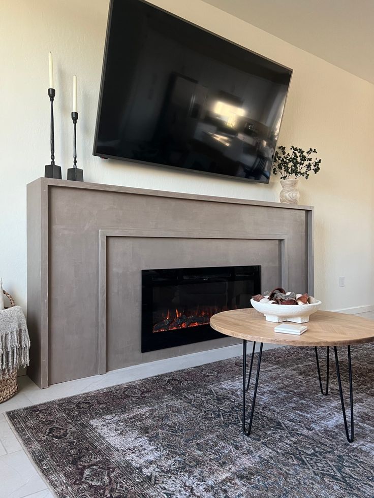 a living room with a fireplace and television above it