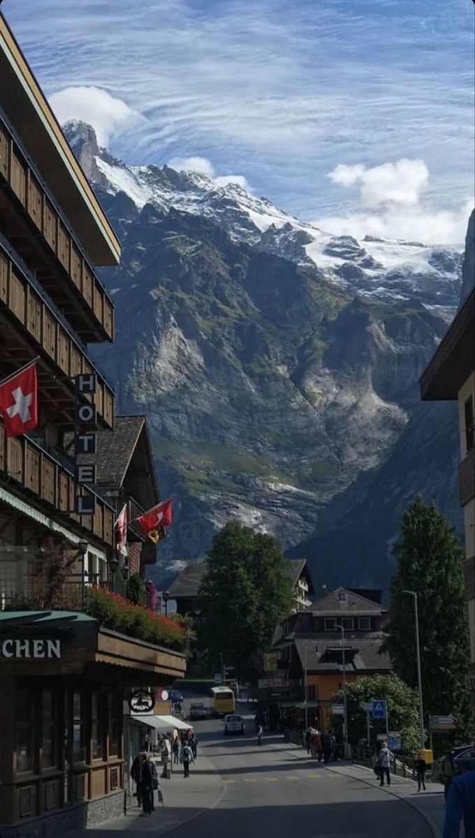 a street with buildings and mountains in the background