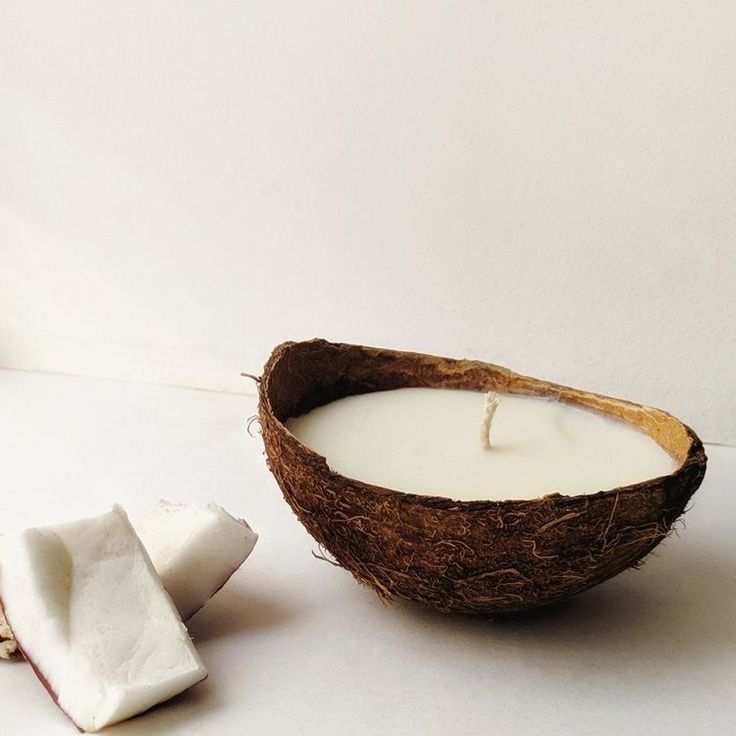 a coconut shell next to a white candle