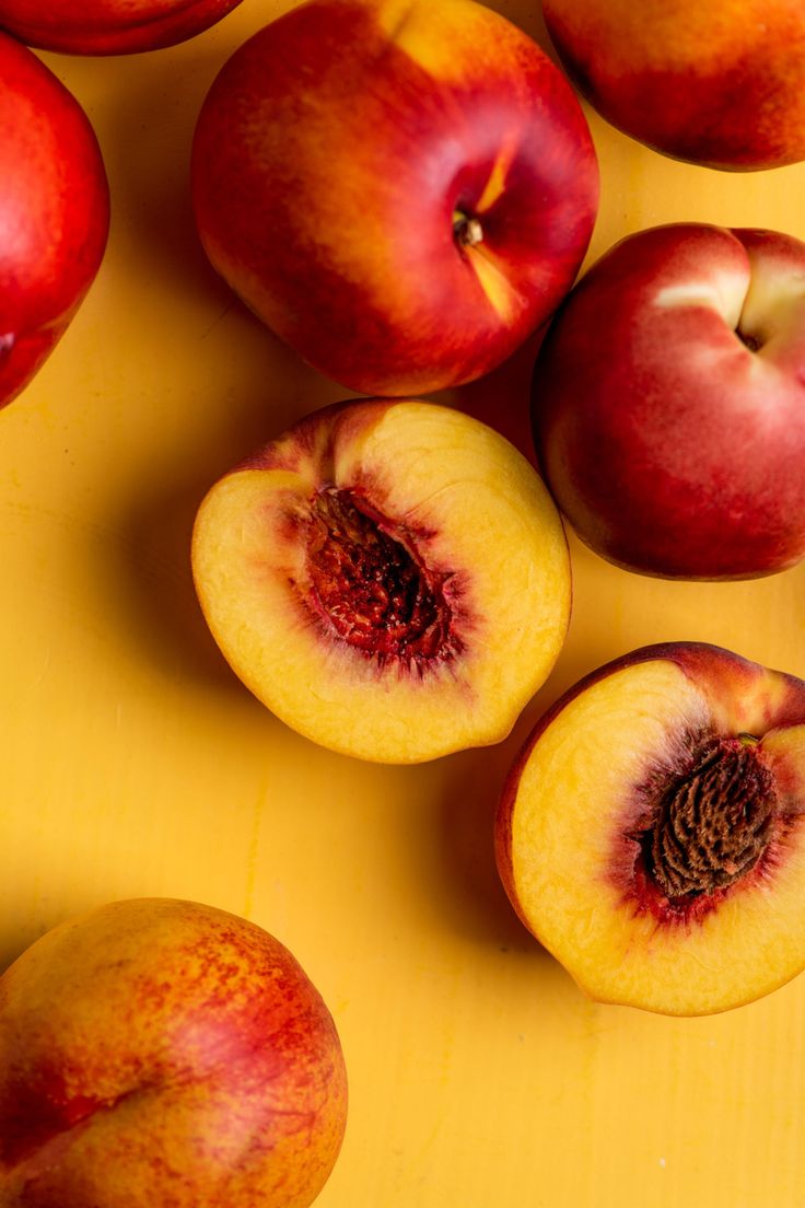 several pieces of fruit sitting on top of a yellow surface