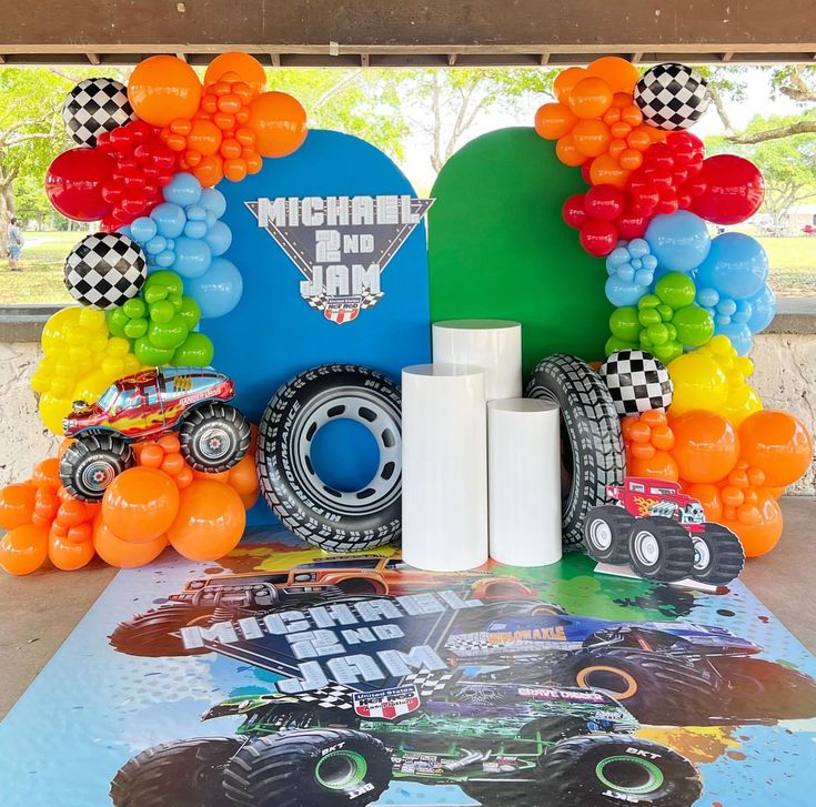 a table topped with balloons and monster trucks