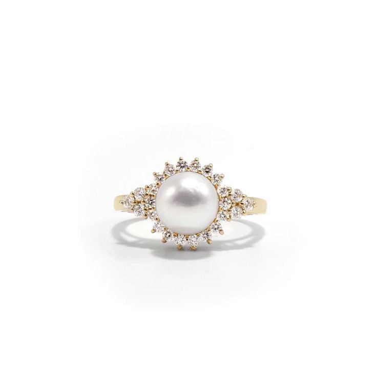 a pearl and diamond ring on a white background