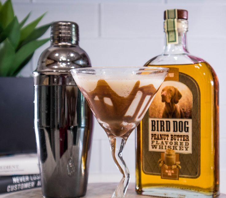 a glass filled with liquid next to a bottle of bird dog rumpled bitterer