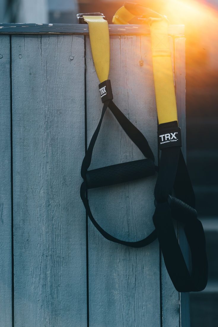 an umbrella hanging on the side of a wooden fence with it's handle up