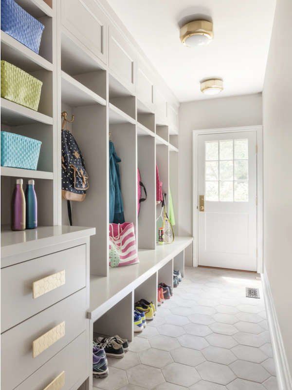 a white walk in closet filled with lots of shelves and drawers next to a door