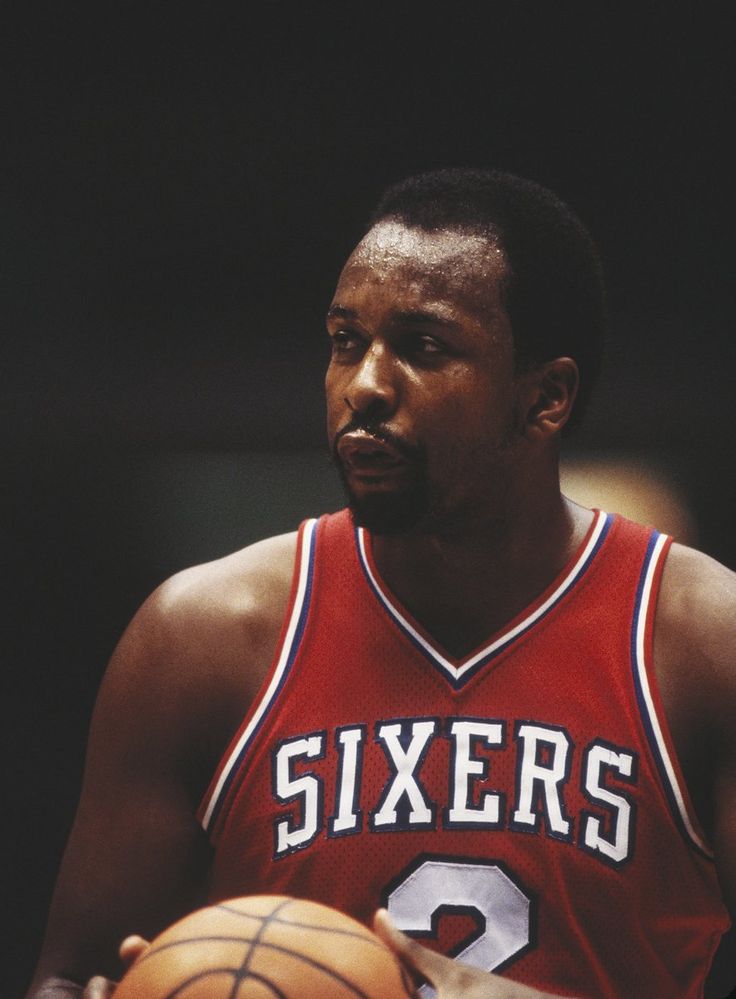 a man holding a basketball in his right hand and wearing a red jersey with the number six on it