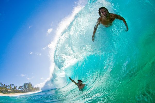 a man riding a wave on top of a surfboard