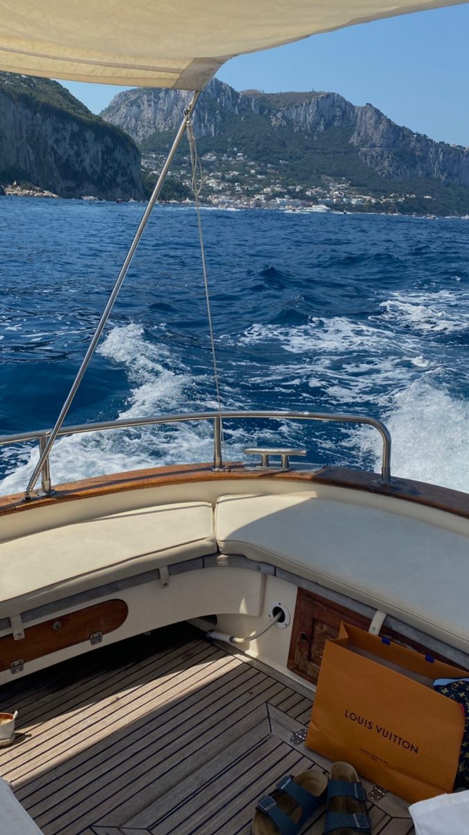 the back end of a boat with mountains in the background