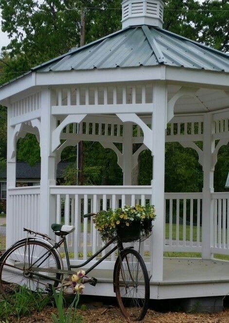 a bicycle parked next to a white gazebo