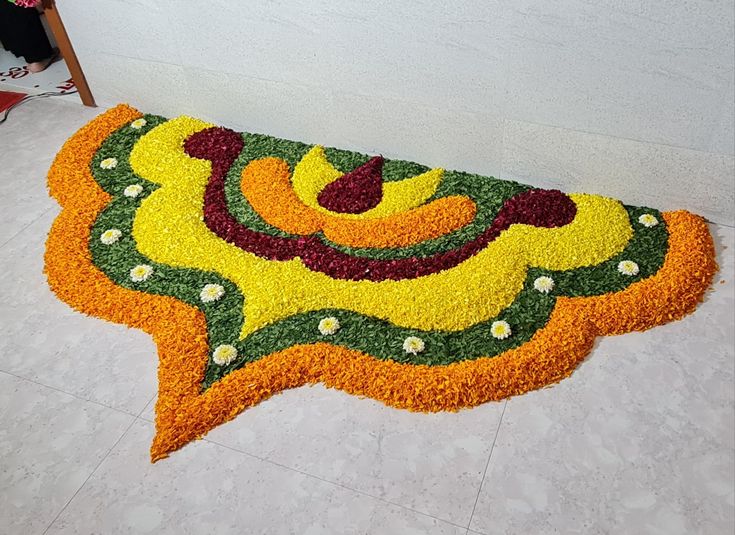 a large flower arrangement on the floor in front of a wall