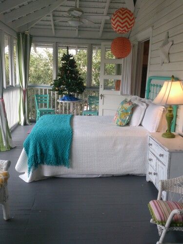 a bed sitting on top of a wooden floor next to a white table and chairs