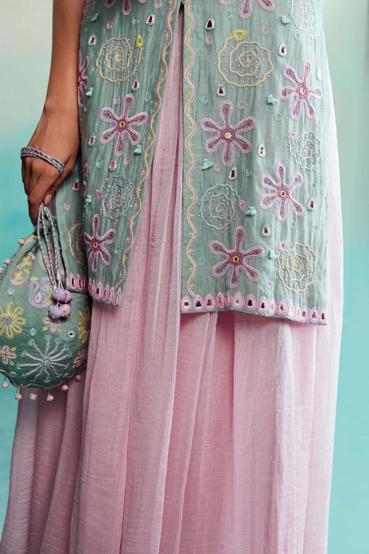 Introducing our exquisite celestial kurta and sharara – a captivating combination of kurta and sharara that embodies elegance and artistry. Meticulously handcrafted, the kurta features intricate floral and spiral motifs inspired by the rich traditions of kutchi embroideries. Radiating a refreshing mint hue, it showcases delightful contrast color embroidery and intricate mirror work, adding allure to its design. Spring Anarkali Set With Mirror Work And Straight Kurta, Bohemian Chanderi Palazzo Set For Eid, Spring Chanderi Sharara With Traditional Drape, Bohemian Chanderi Sharara For Eid, Spring Festive Sharara With Cutdana, Bohemian Palazzo Set With Straight Kurta And Dupatta, Bohemian Straight Kurta Anarkali Set, Spring Sharara With Straight Kurta And Intricate Embroidery, Spring Sharara With Intricate Embroidery And Straight Kurta