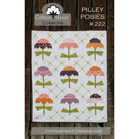 a quilted wall hanging on the side of a wooden fence with an image of umbrellas