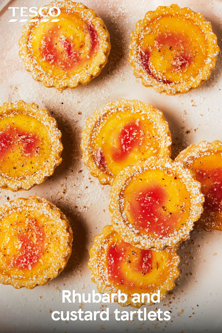 small desserts are arranged on a plate with powdered sugar and jelly toppings