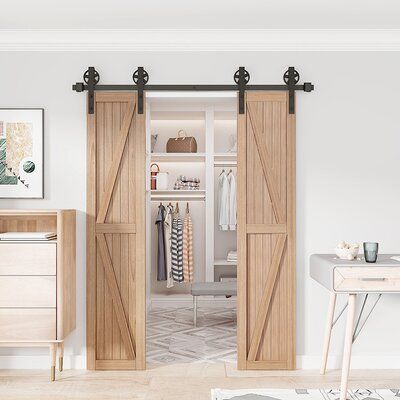 an open closet with sliding doors and drawers in the corner, next to a desk