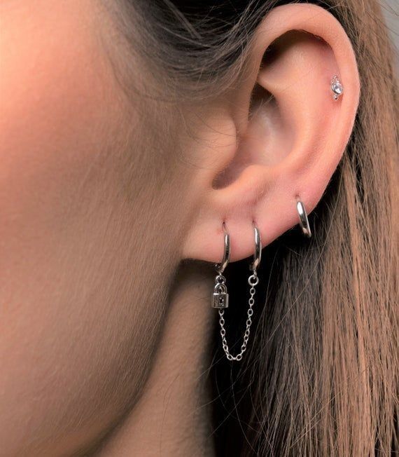 a close up of a person's ear with two piercings attached to it