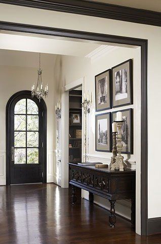 an entryway with pictures on the wall and wooden floors