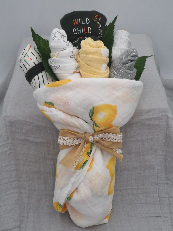 a baby shower gift wrapped in a yellow and white blanket