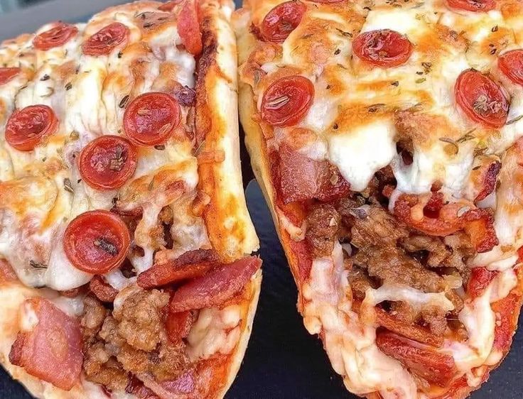 two slices of pizza with meat, cheese and pepperoni