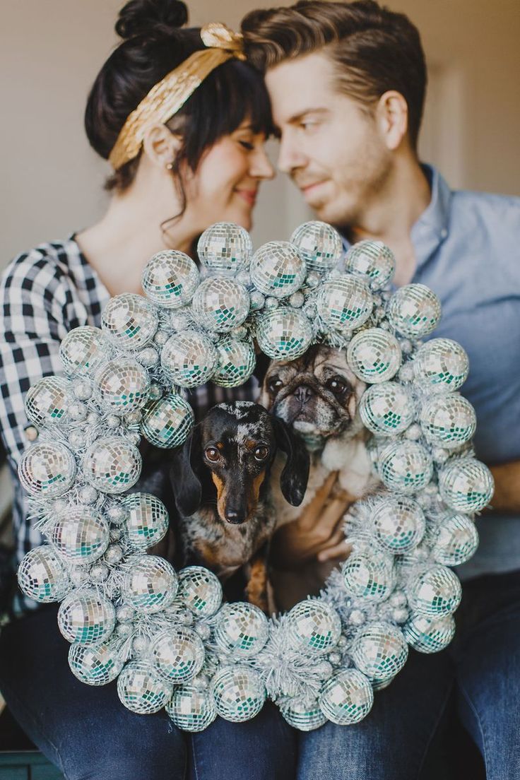 a man and woman sitting next to each other with a dog in front of them