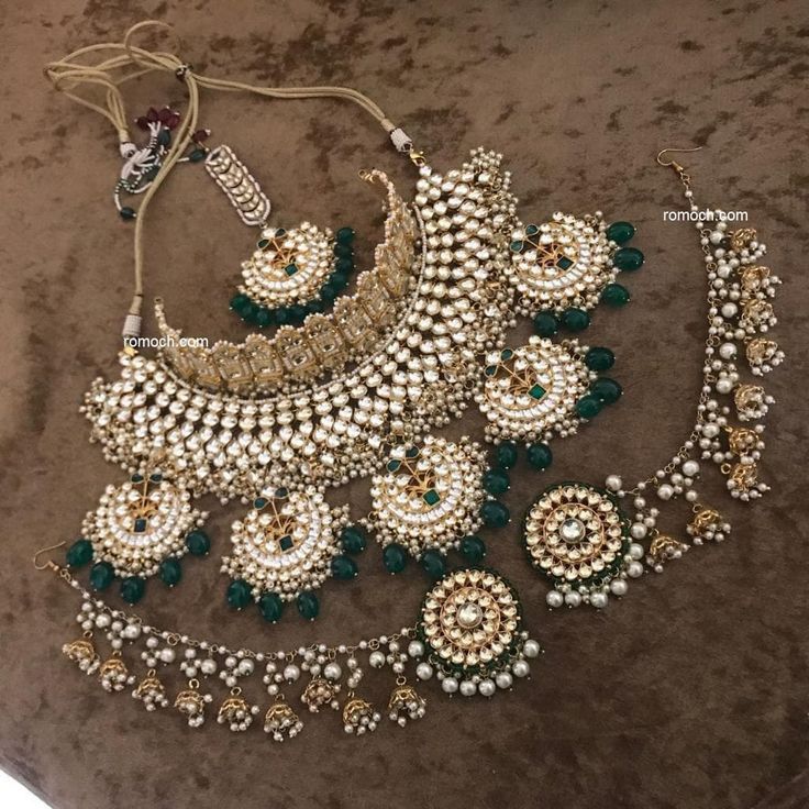 an elaborate necklace and earring set with pearls, emerald green beads and white stones