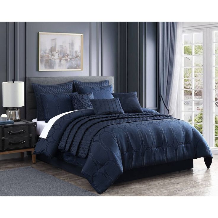 a bed with blue comforters and pillows