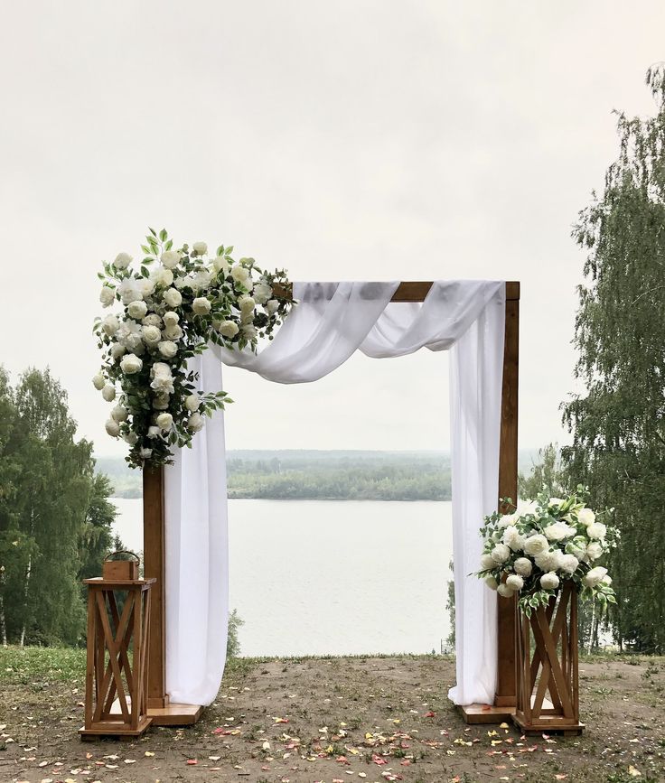 an outdoor wedding setup with white flowers and greenery