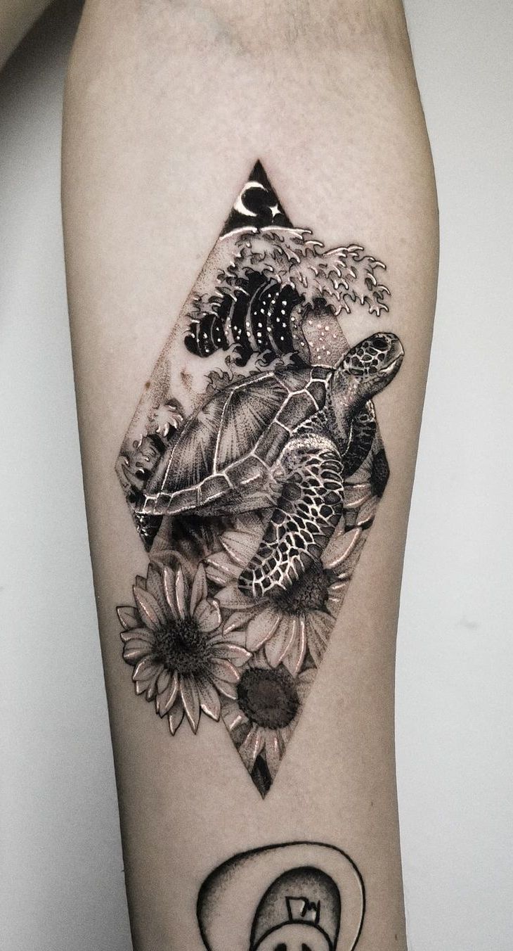 a turtle and sunflowers tattoo on the right thigh with a triangle in the middle