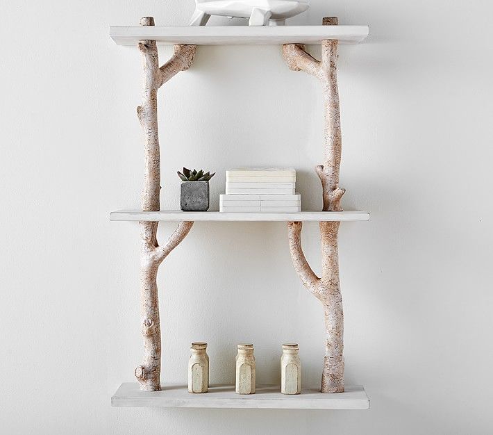 two white shelves with books and vases on them in front of a wall mounted shelf