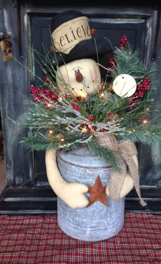 a potted plant with a snowman in it and a star on the top