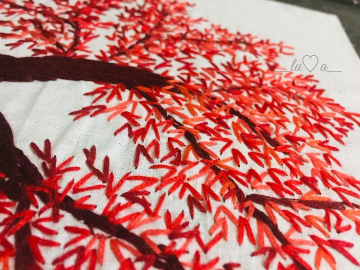 the red leaves are on the white table cloth