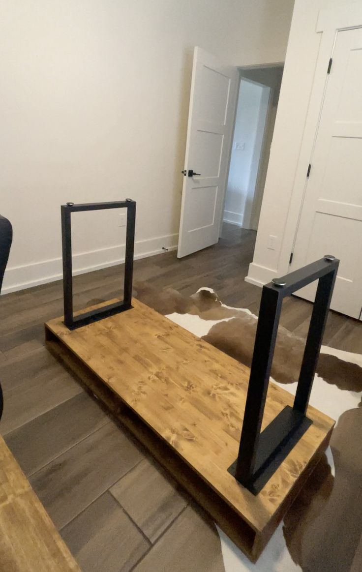 an empty room with two chairs and a table in the middle, on top of a cowhide rug