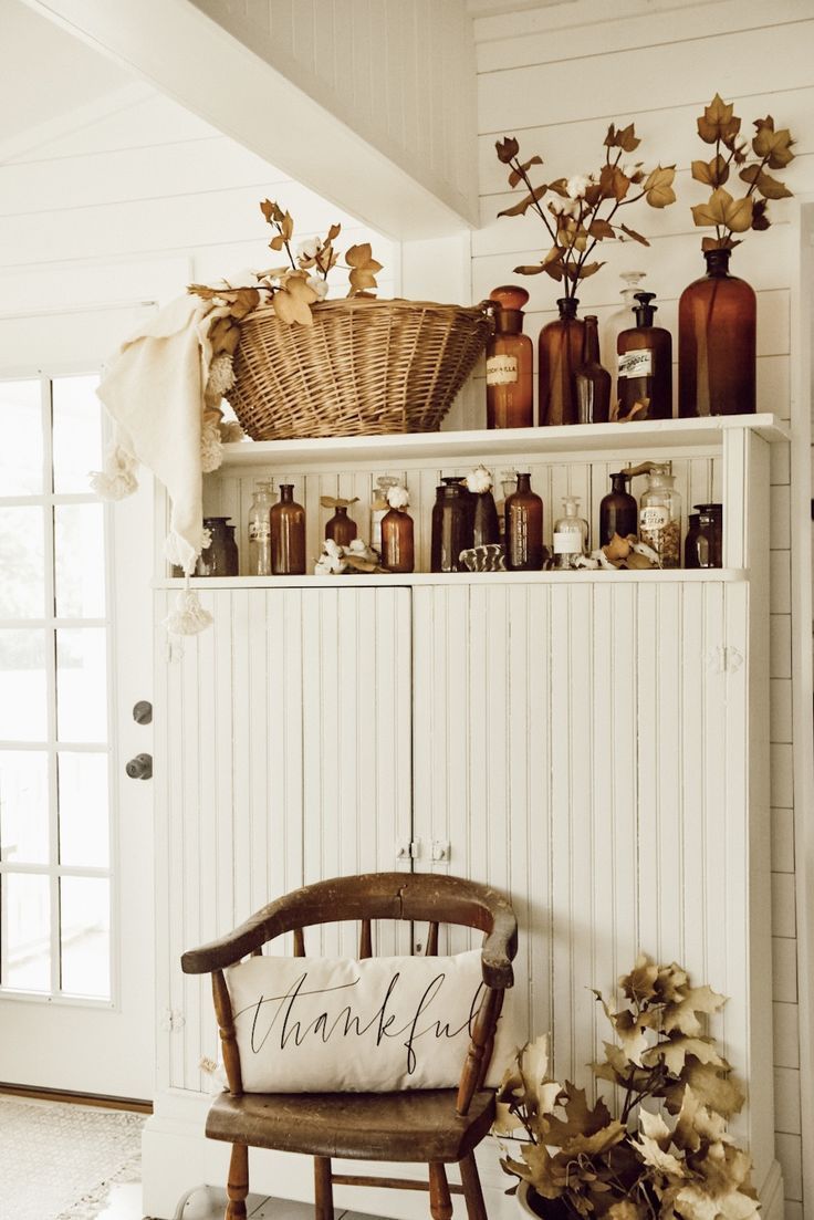 a wooden chair sitting next to a shelf filled with bottles and vases on top of it