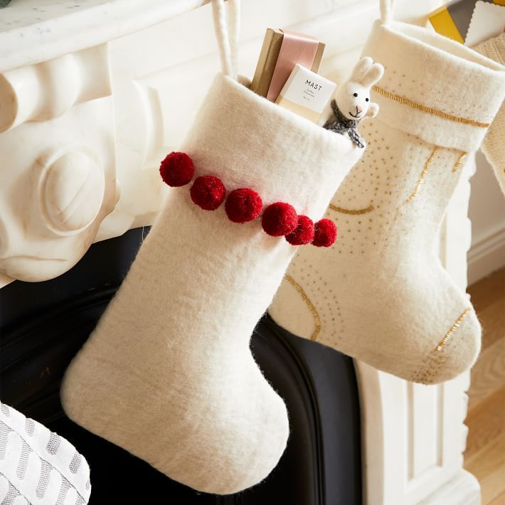 two stockings with pom - poms hanging from them