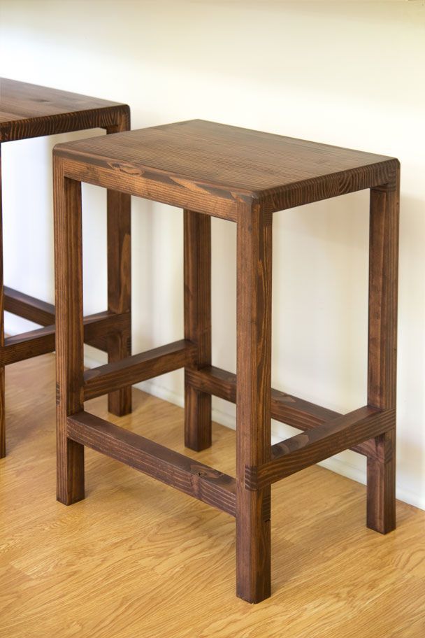 two wooden stools sitting next to each other on top of a hard wood floor