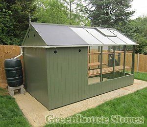 a small green shed with a wooden deck