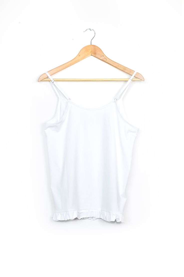 Our Isla women's white camisole top balances the bold patterns of our pyjama bottoms or shorts. Featuring spaghetti straps across a scooped, slightly gathered neckline, and a cute flounced hem that hits at the waist, this tank top easily transitions between loungewear and an everyday piece. Tina is 171cm / 5' 8'' and wears size S Stretch Sleepwear With Built-in Bra For Summer, Summer Tank Top With Spaghetti Straps For Daywear, Cotton Tank Top With Adjustable Ruffled Straps, White Stretch Sleeveless Sleepwear, White Sleeveless Stretch Sleepwear, Summer Camisole With Built-in Bra And Ruffled Straps, Cotton Camisole With Ruffled Straps For Summer, Summer Cotton Camisole With Ruffled Straps, Spring White Camisole With Delicate Straps