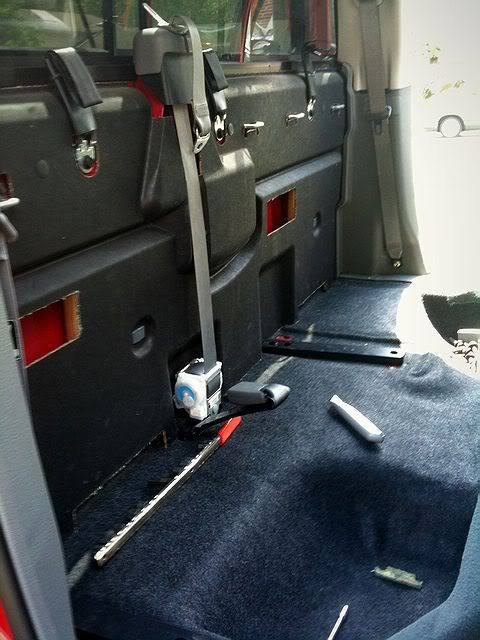 the inside of a vehicle with its door open and tools on the floor next to it