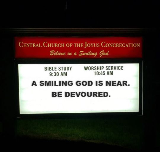 a sign that is lit up with the words, a smiling god is near be devoured