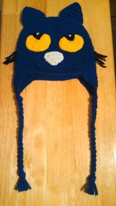 a crocheted cat hat on top of a wooden table