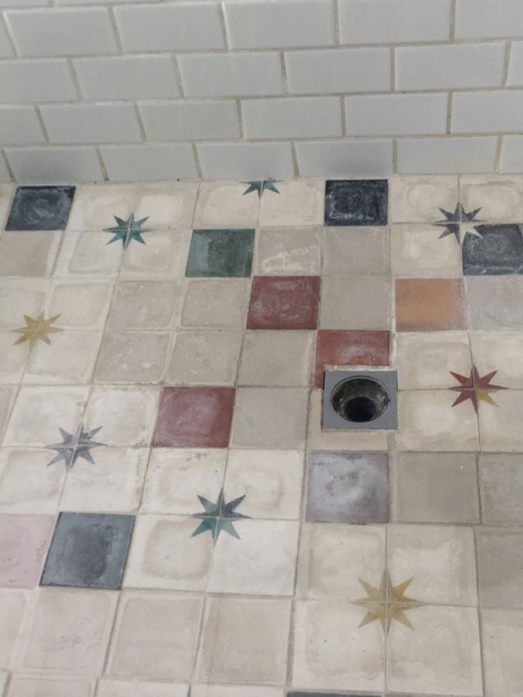 a tiled floor with stars on it and a hole in the middle that is surrounded by smaller tiles