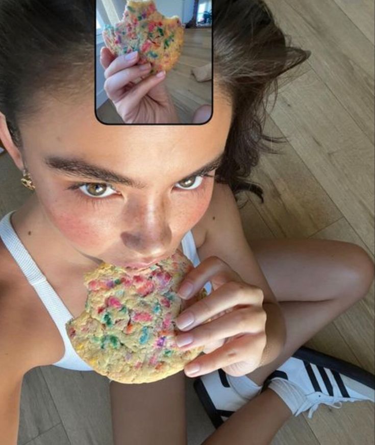 a woman eating a cookie with sprinkles on it