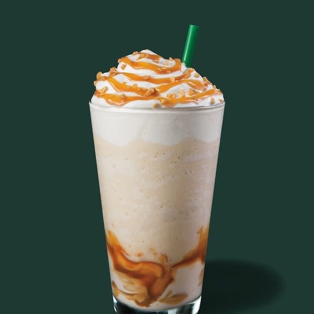 an iced drink with caramel and whipped cream on the top, sitting on a green background