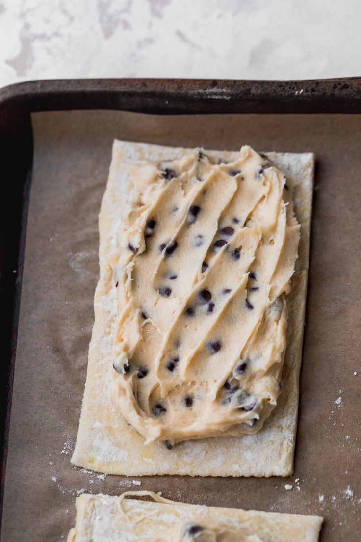 two flatbreads with peanut butter and chocolate chips on them sitting on a baking sheet